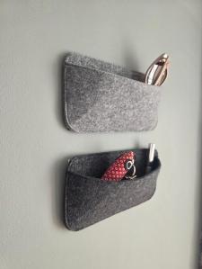 Camper Organizer aus Filz an der Seitenwand im Wohnwagen, mit Brille und Kabeln befüllt